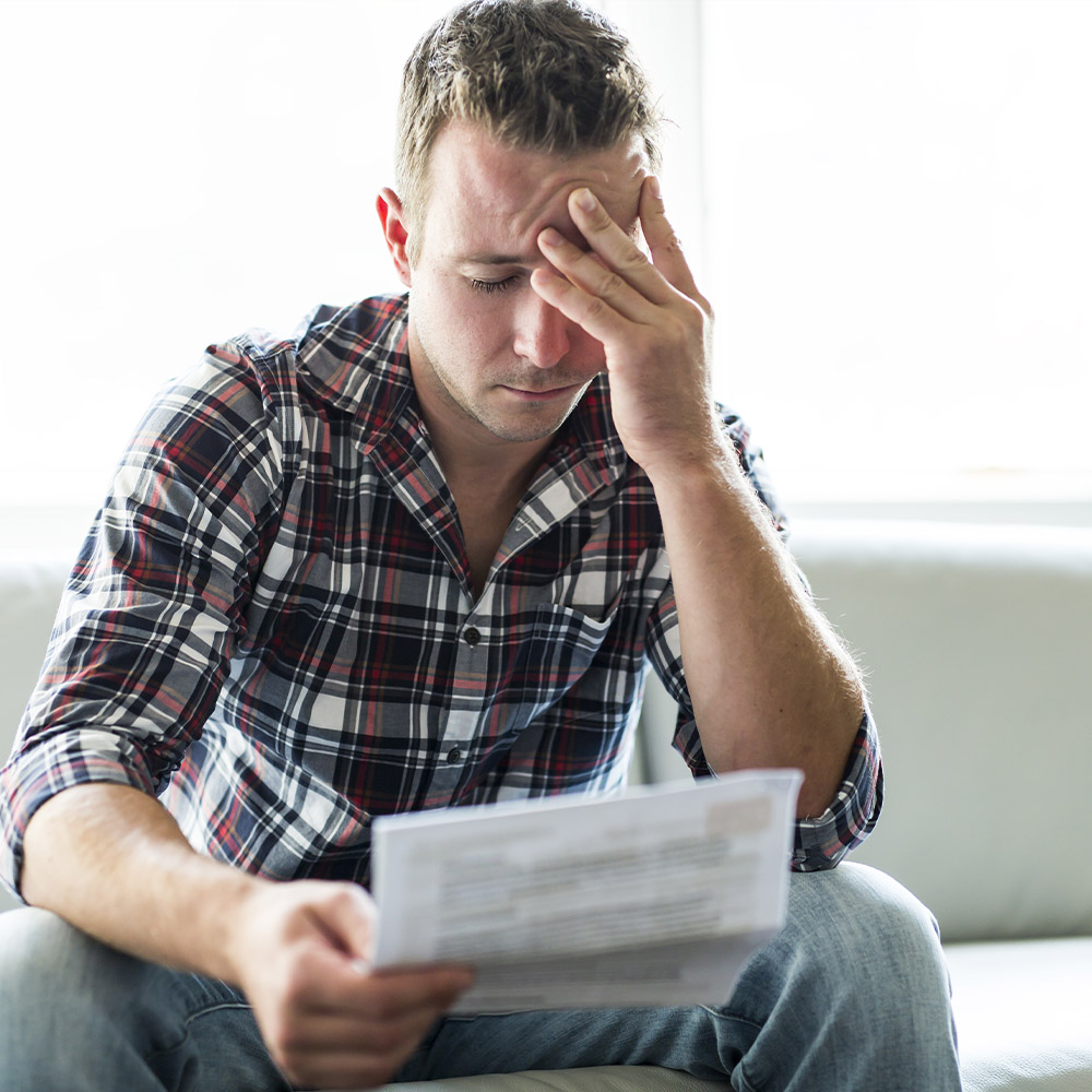 stressed man looking at medical bill