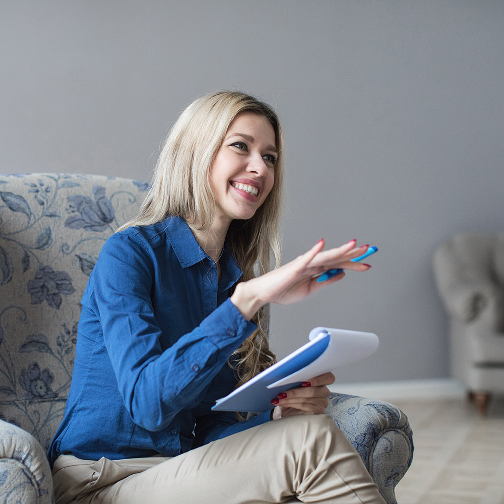 female psychologist with notepad sitting in chair