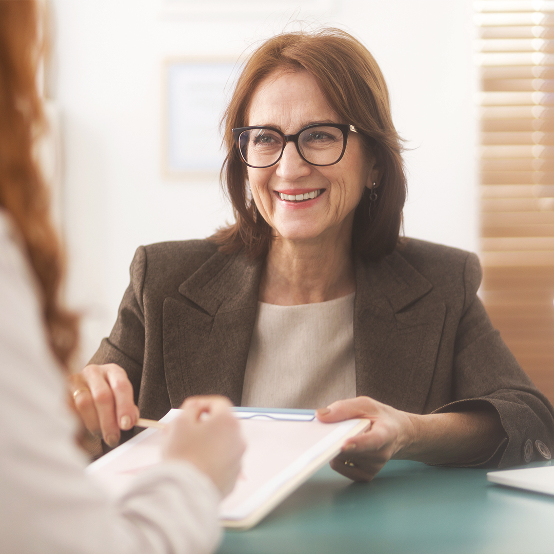 counseler giving her patient paperwork to sign