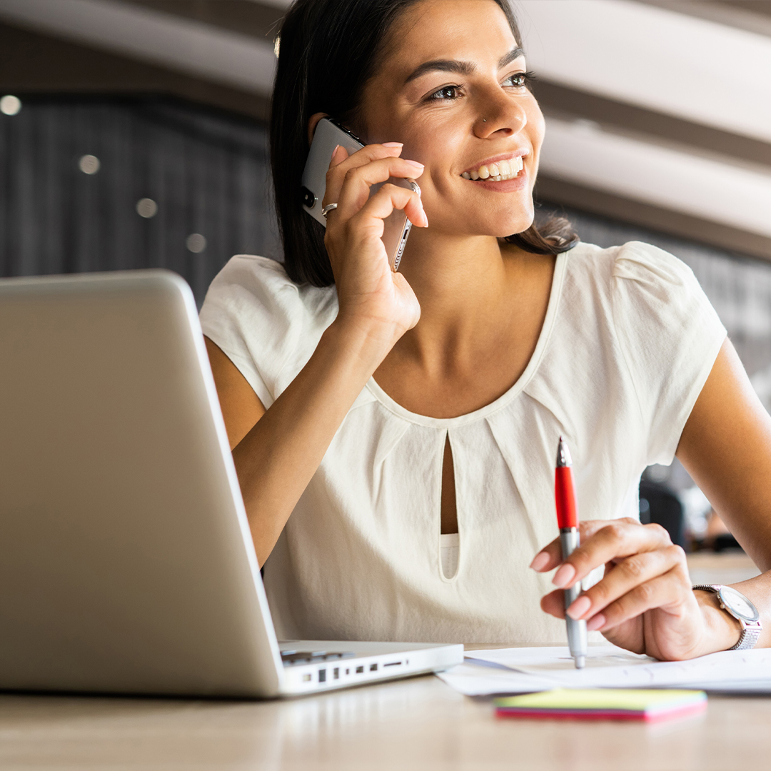 Woman using laptop while on the phone